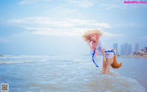 A woman in a straw hat on the beach.