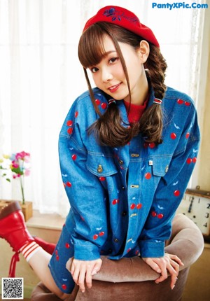 A woman in a blue and white pajamas standing in front of a door.