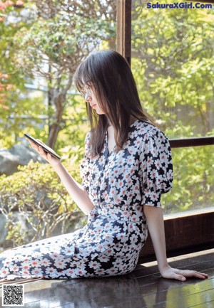 A close up of a woman's face looking out a window.