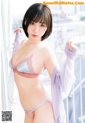 A woman in a pink bikini sitting on a white surface.