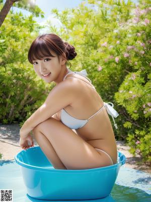 A woman in a white bikini posing on a beach.