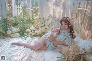 A woman in a blue and white lingerie sitting on a bed.