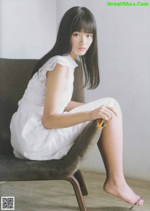 A woman with long black hair and bangs is posing for a picture.