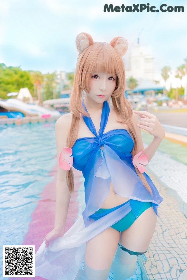A woman in a blue bikini standing in a pool.