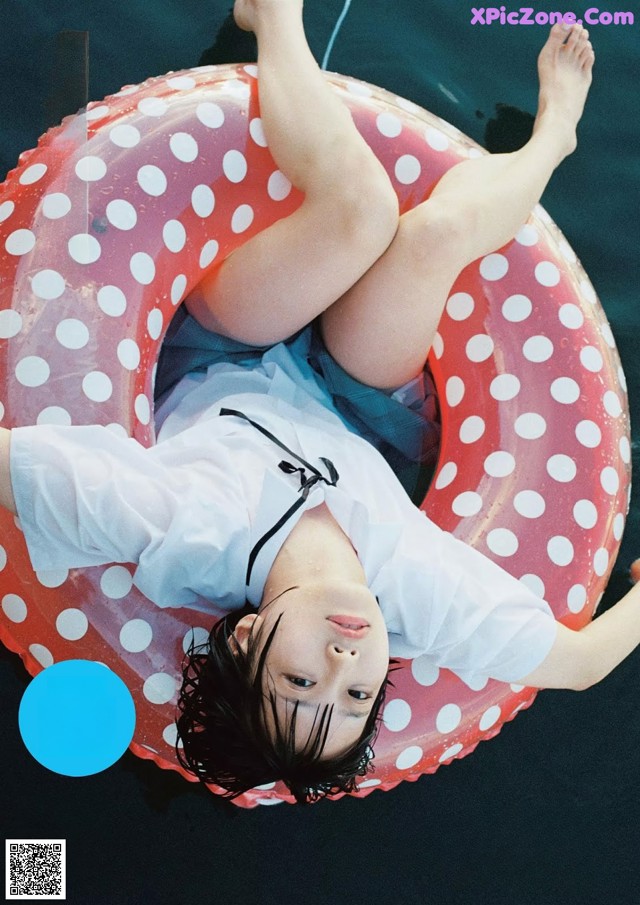 A woman floating on an inflatable ring in the water.