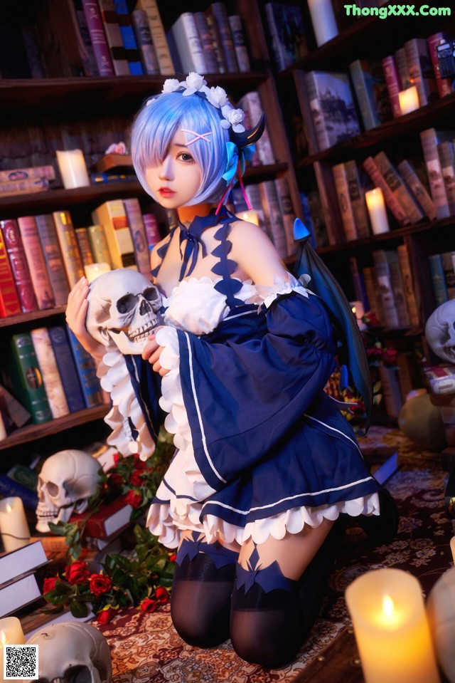 A woman in a blue and white dress holding a skull.