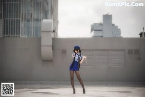 A woman in a blue uniform holding a gun.