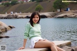 A woman in a black bra sitting in a green chair.