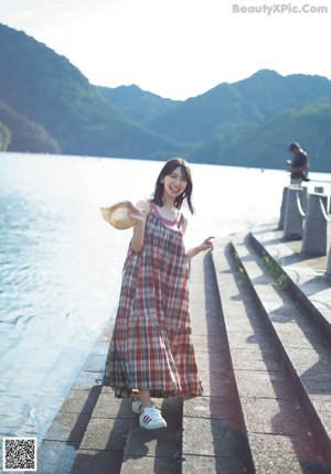 A young woman in a white shirt smiles at the camera.