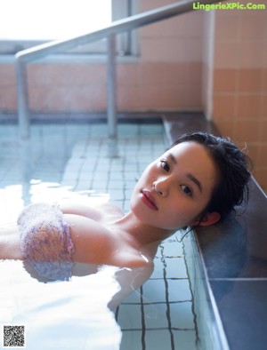 A woman in a bikini laying on a bed.