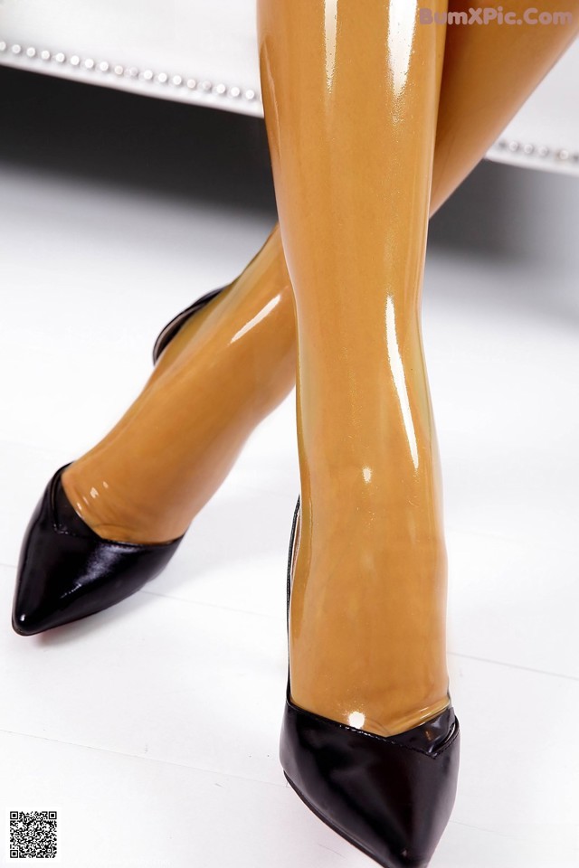 A close up of a woman's legs wearing black shoes.