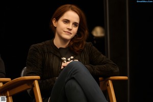 A woman in stockings and high heels sitting on a desk.