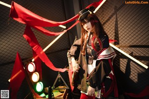 A woman in a red and black outfit holding a sword.