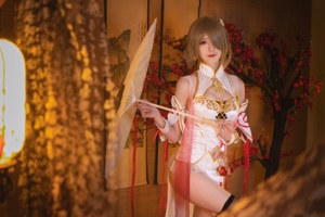 A woman in a white and red outfit holding a fan.