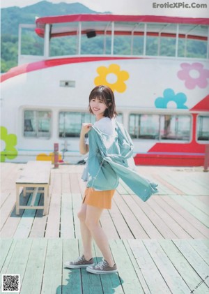 A young woman standing in front of a green wall.