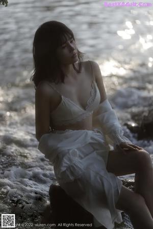 A woman in a white lingerie laying on the ground.