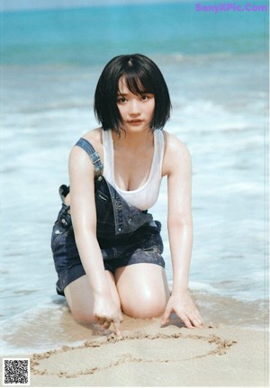 A woman in a white dress sitting on the ground.