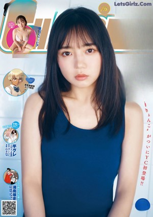 A young woman sitting on a chair wearing a blue cardigan.