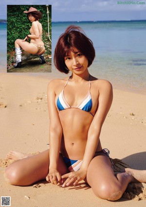A woman in a bikini and stockings posing for a picture.