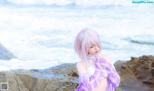 A woman in a bikini sitting on the beach.